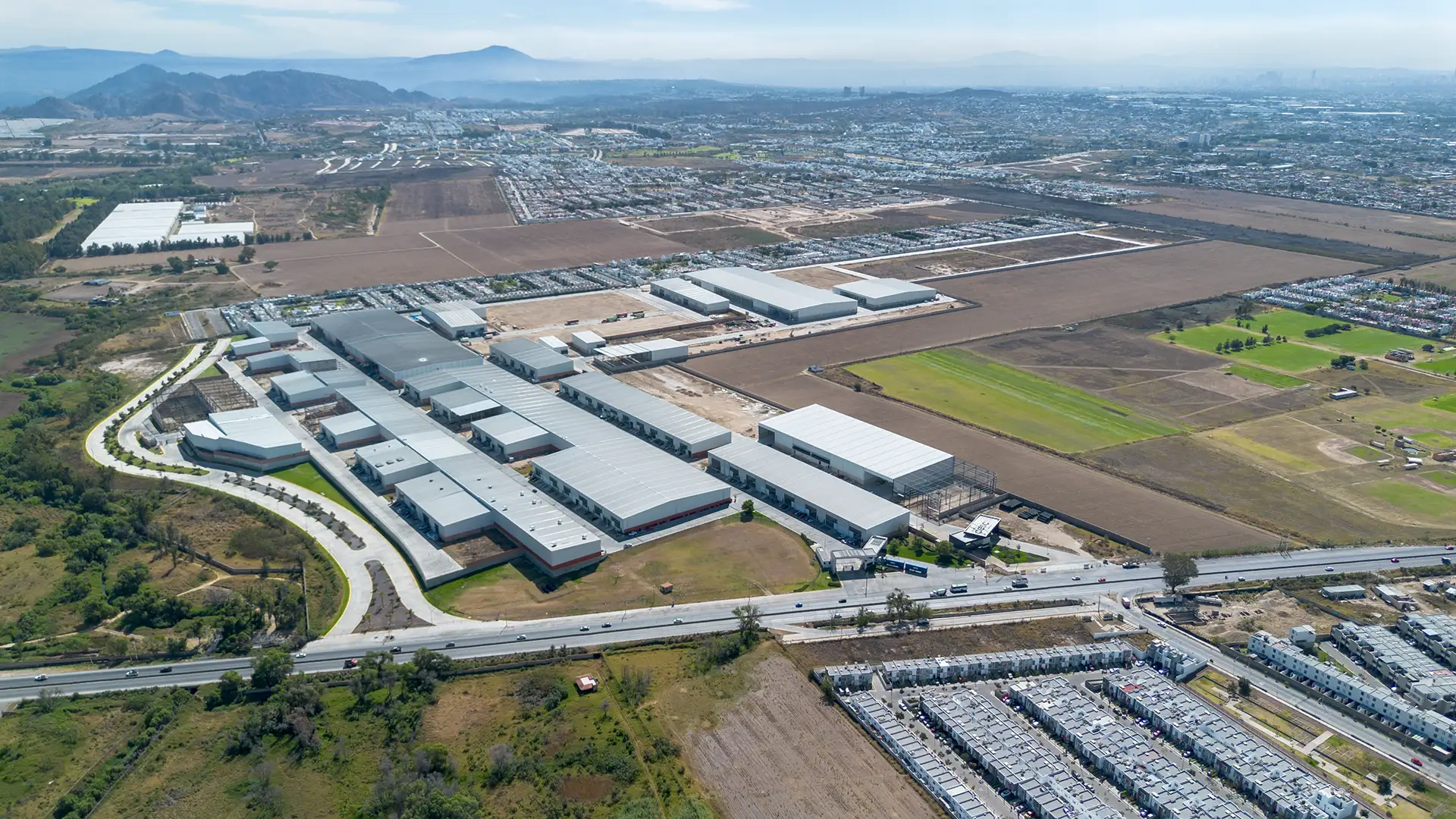 Vista aérea de un parque industrial de Grupo Cesco, con naves alineadas junto a la vialidad principal